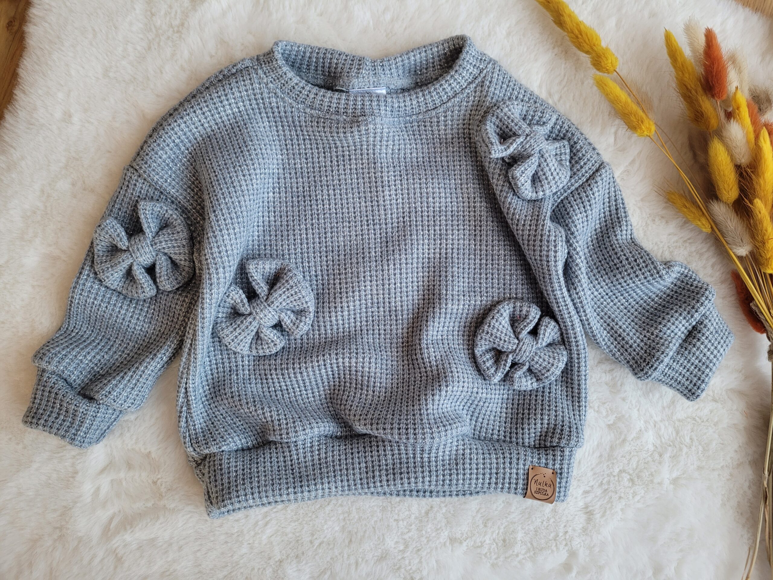 Sweterek dla dziewczynki z kokardkami błękitny
